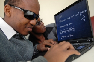 person with opaque glasses reading computer with huge font display